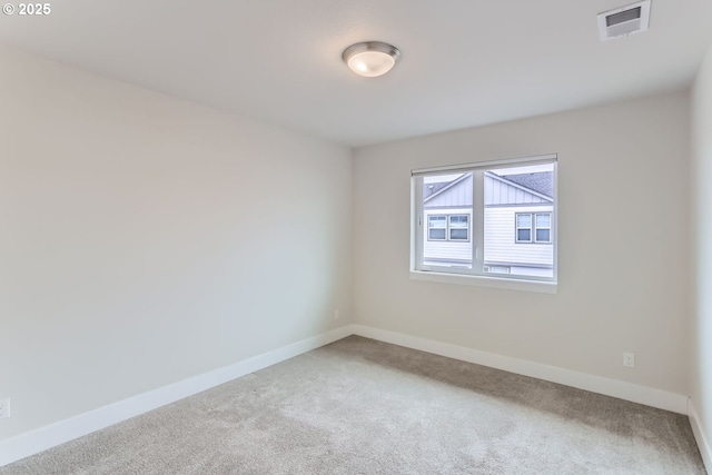 carpeted spare room featuring visible vents and baseboards