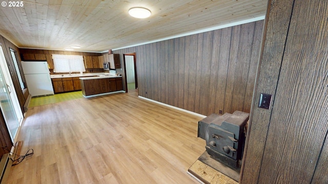 33080 Lupine Way Rd, Gold Beach, OR 97444 - kitchen with freestanding refrigerator, light countertops, a wood stove, wood walls, and open floor plan