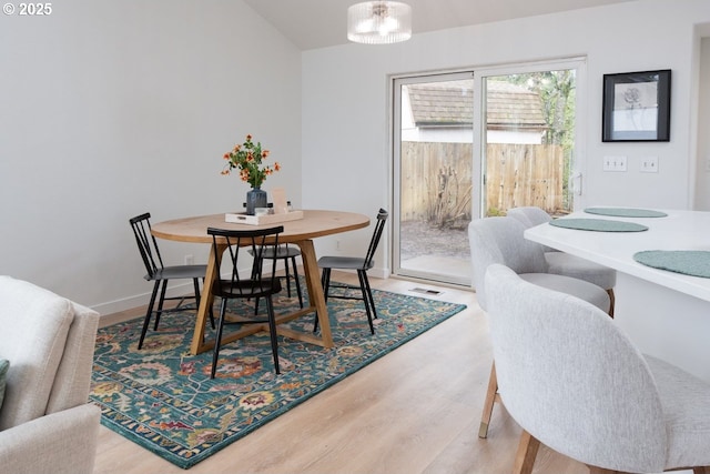 dining room with visible vents, wood finished floors, baseboards, and a chandelier