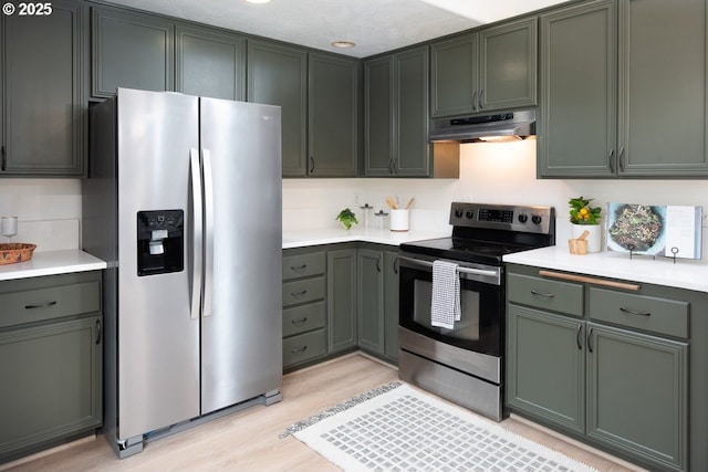 kitchen featuring under cabinet range hood, light wood-style floors, appliances with stainless steel finishes, and light countertops