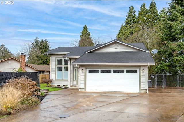 view of front of home with a shingled roof, an attached garage, concrete driveway, and fence