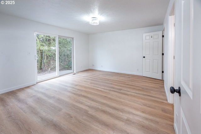 empty room with light wood finished floors and baseboards