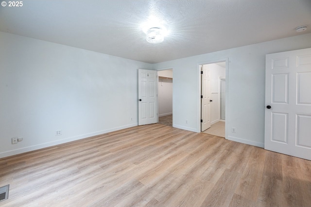 unfurnished bedroom featuring visible vents, baseboards, and light wood-style floors