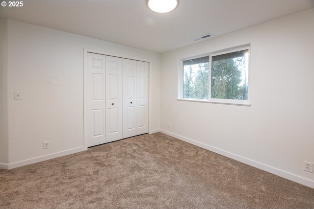 unfurnished bedroom with a closet, baseboards, visible vents, and carpet floors