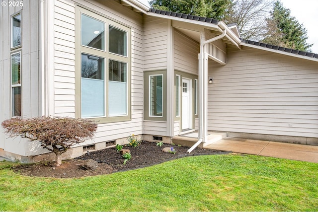 property entrance featuring crawl space and a lawn