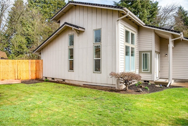 view of property exterior with crawl space, a lawn, and fence