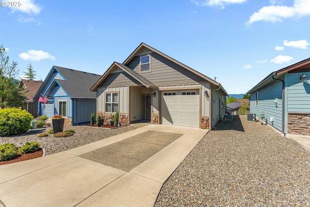 craftsman house with concrete driveway, a garage, stone siding, board and batten siding, and central AC