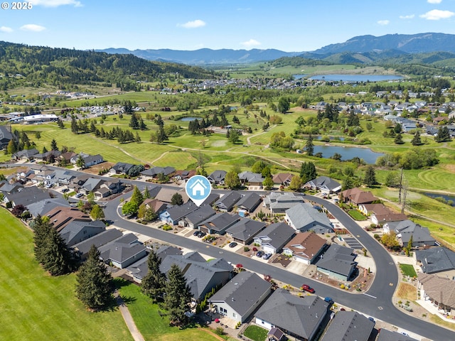 aerial overview of property's location featuring a water and mountain view and nearby suburban area