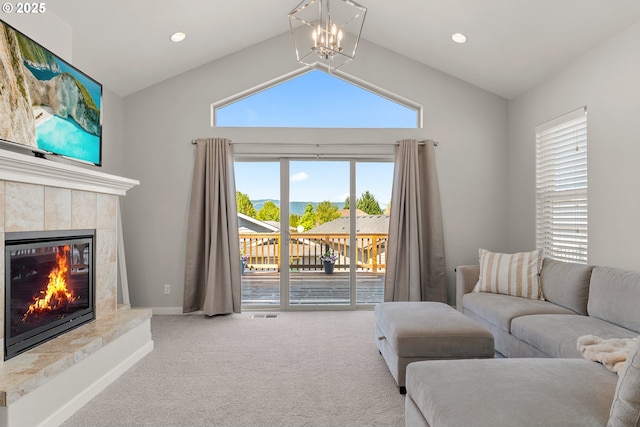 living area featuring carpet floors, a fireplace, vaulted ceiling, healthy amount of natural light, and a water view