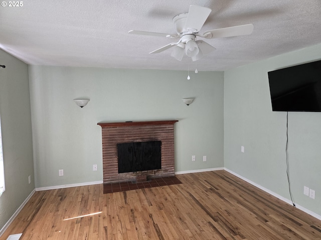1625 Jackson St, Albany, OR 97322 - unfurnished living room featuring a textured ceiling, wood finished floors, a ceiling fan, and a brick fireplace