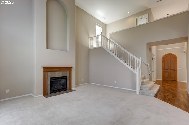 13605 NW Hogan St, Portland, OR 97229 - unfurnished living room with carpet, stairway, baseboards, and a towering ceiling