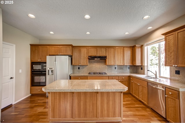 13605 NW Hogan St, Portland, OR 97229 - kitchen with tile countertops, black appliances, a sink, a kitchen island, and light wood-type flooring