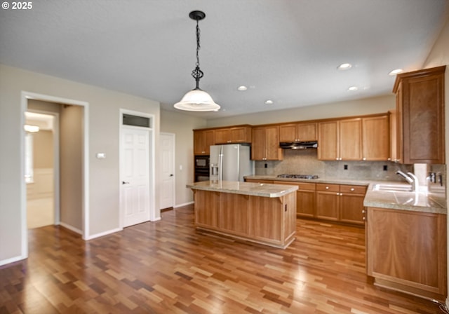 13605 NW Hogan St, Portland, OR 97229 - kitchen featuring stainless steel appliances, under cabinet range hood, wood finished floors, light countertops, and a kitchen island