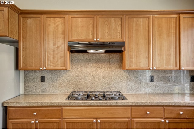 13605 NW Hogan St, Portland, OR 97229 - kitchen with under cabinet range hood, stainless steel gas stovetop, decorative backsplash, and brown cabinets