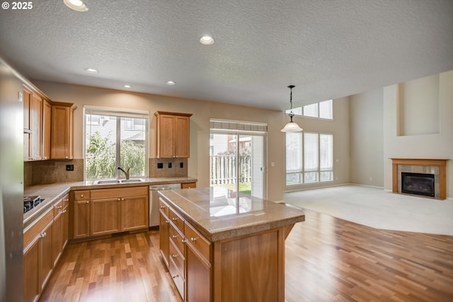 13605 NW Hogan St, Portland, OR 97229 - kitchen featuring light wood-type flooring, dishwasher, a textured ceiling, healthy amount of natural light, and a kitchen island