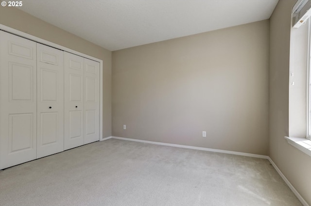 13605 NW Hogan St, Portland, OR 97229 - unfurnished bedroom with light carpet, baseboards, and a closet