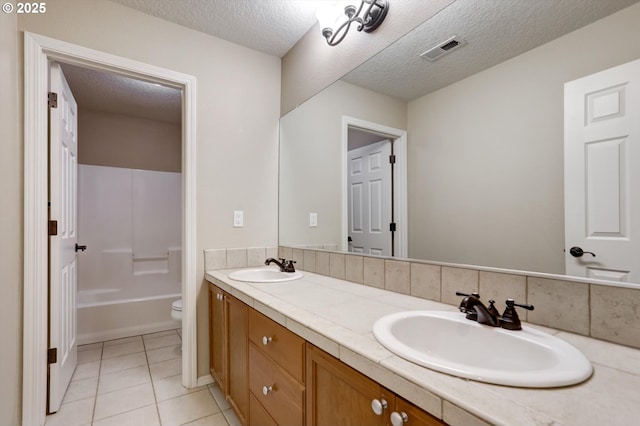 13605 NW Hogan St, Portland, OR 97229 - bathroom featuring toilet, double vanity, tile patterned flooring, a textured ceiling, and shower / bathtub combination