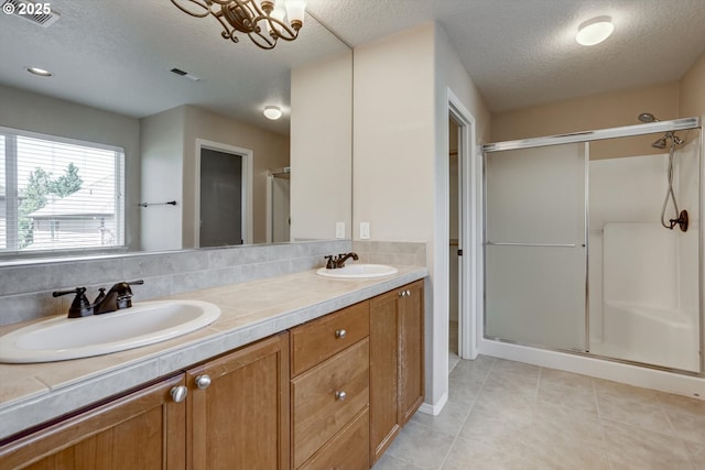 13605 NW Hogan St, Portland, OR 97229 - bathroom with a stall shower, a textured ceiling, double vanity, tile patterned floors, and backsplash