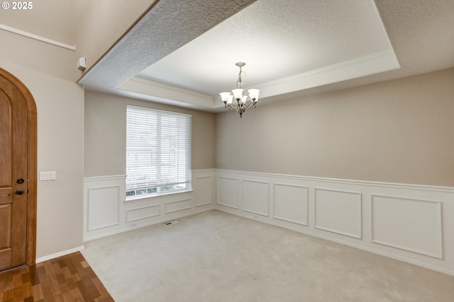 13605 NW Hogan St, Portland, OR 97229 - spare room with a raised ceiling, a chandelier, a wainscoted wall, ornamental molding, and wood finished floors