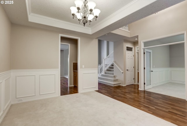 13605 NW Hogan St, Portland, OR 97229 - empty room featuring a chandelier, ornamental molding, stairway, wood finished floors, and a decorative wall