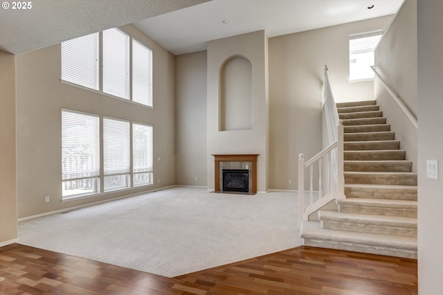 13605 NW Hogan St, Portland, OR 97229 - unfurnished living room with stairs, a fireplace, baseboards, wood finished floors, and carpet flooring