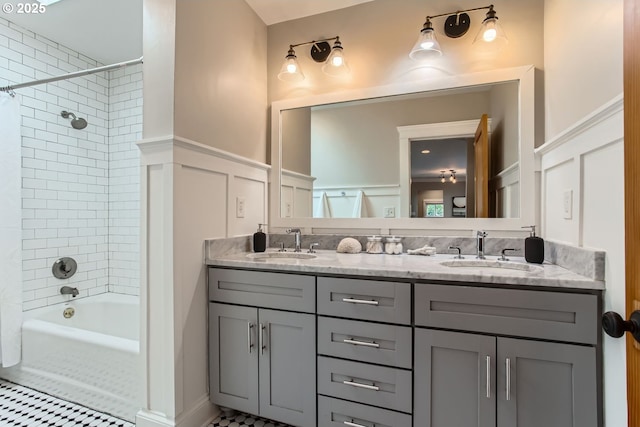 full bath featuring shower / tub combo, a sink, a decorative wall, and double vanity