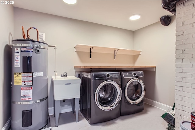 laundry room featuring water heater, a sink, laundry area, independent washer and dryer, and baseboards