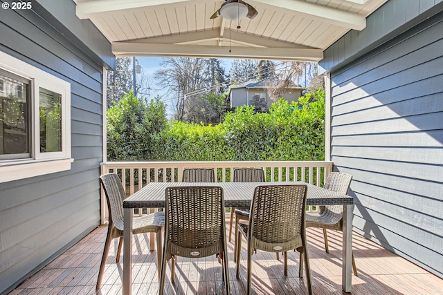 wooden deck featuring outdoor dining space and ceiling fan