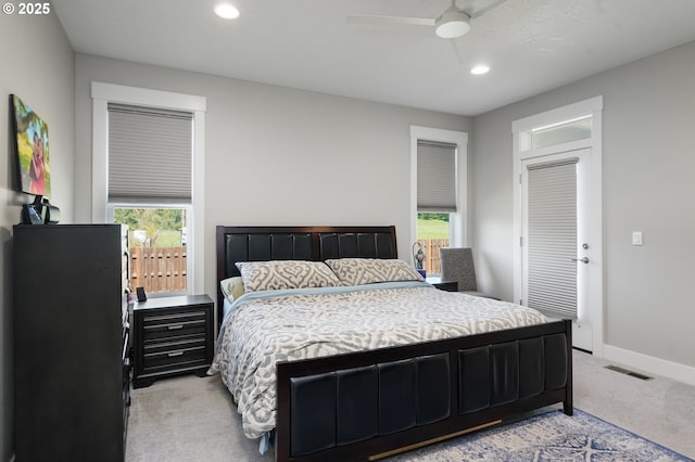 bedroom with light carpet, multiple windows, visible vents, and baseboards