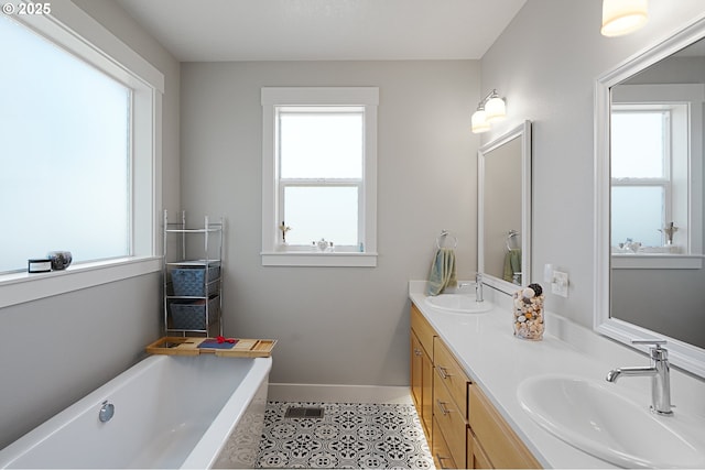 full bathroom featuring a bathing tub, a sink, and a wealth of natural light