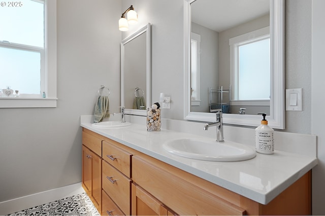 full bathroom with double vanity, baseboards, a sink, and tile patterned floors