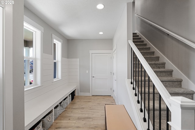 mudroom with a textured ceiling, baseboards, light wood-style flooring, and recessed lighting