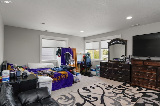 carpeted bedroom featuring visible vents, a textured ceiling, and recessed lighting