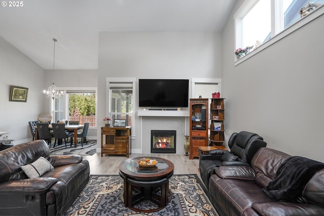 living area with a healthy amount of sunlight, a lit fireplace, and wood finished floors