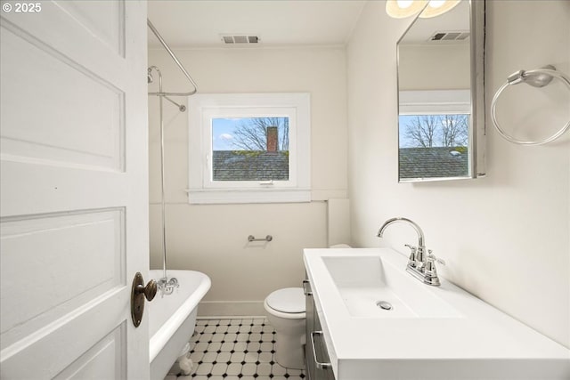 bathroom with toilet, vanity, a tub, and a wealth of natural light