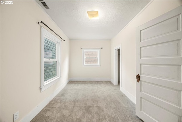 hallway with light carpet and a textured ceiling