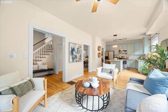 living room with light hardwood / wood-style floors and ceiling fan