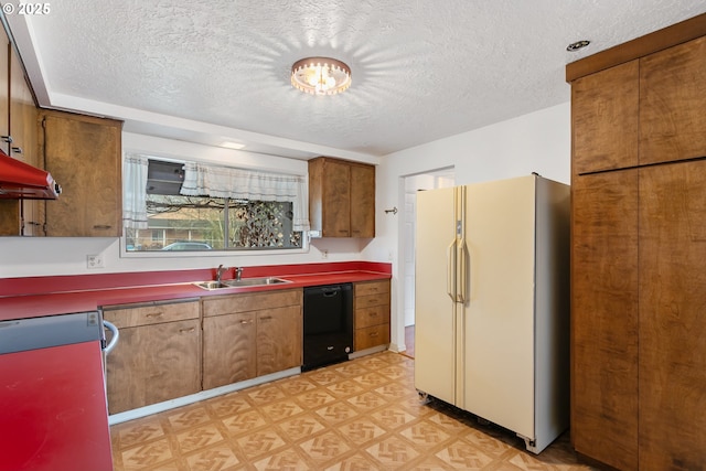 kitchen featuring dishwasher, sink, white fridge, and a textured ceiling