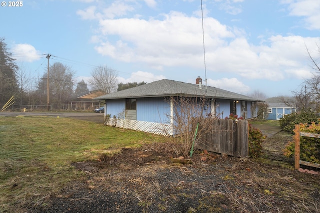 view of side of home with a yard