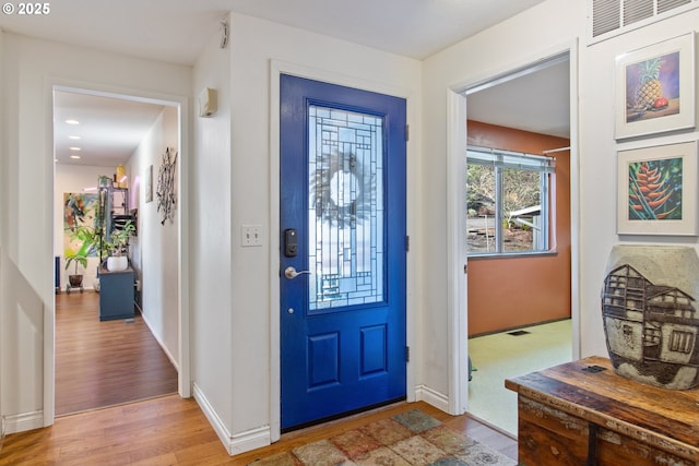 foyer with visible vents, baseboards, and light wood finished floors