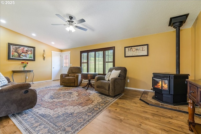 18203 S Windy City Rd, Mulino, OR 97042 - living area featuring a wood stove, light wood-style floors, ceiling fan, baseboards, and vaulted ceiling