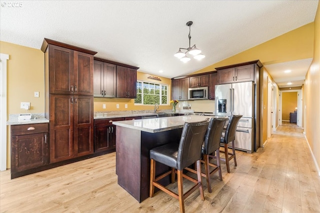 18203 S Windy City Rd, Mulino, OR 97042 - kitchen featuring stainless steel appliances, light wood finished floors, a kitchen bar, a kitchen island, and dark brown cabinets