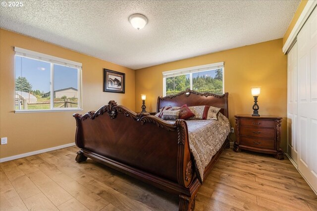 18203 S Windy City Rd, Mulino, OR 97042 - bedroom featuring light wood-style floors, a closet, a textured ceiling, and baseboards