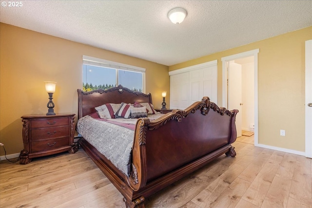18203 S Windy City Rd, Mulino, OR 97042 - bedroom featuring light wood finished floors, a textured ceiling, a closet, baseboards, and ensuite bath