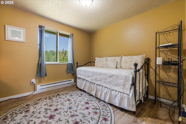 18203 S Windy City Rd, Mulino, OR 97042 - bedroom featuring a baseboard heating unit, a textured ceiling, wood finished floors, and baseboards