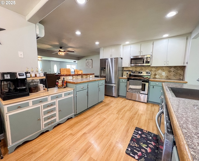 858 E Main St, John Day, OR 97845 - kitchen with appliances with stainless steel finishes, a sink, light wood-style floors, ceiling fan, and backsplash