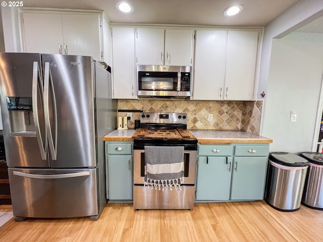 858 E Main St, John Day, OR 97845 - kitchen with appliances with stainless steel finishes, light wood-type flooring, light countertops, backsplash, and recessed lighting
