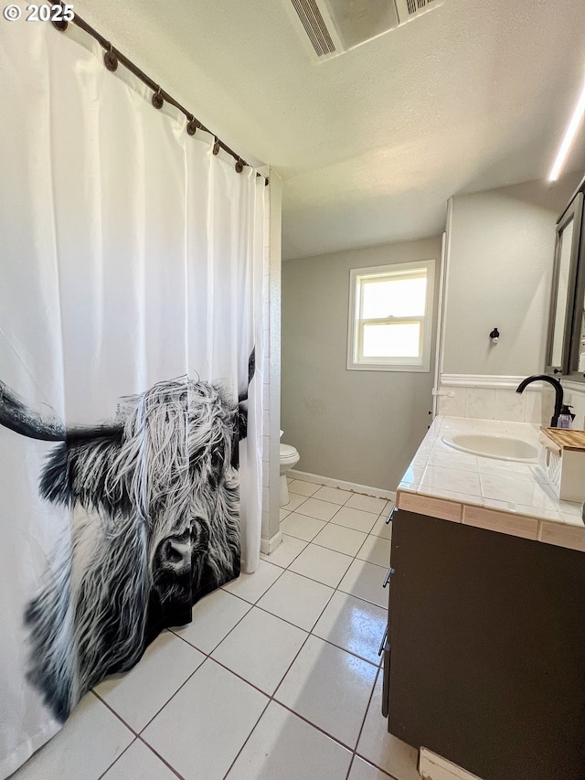 858 E Main St, John Day, OR 97845 - full bathroom featuring vanity, toilet, tile patterned floors, and baseboards