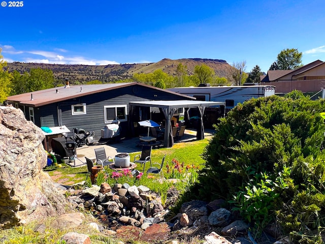 858 E Main St, John Day, OR 97845 - rear view of property featuring a patio area and a mountain view