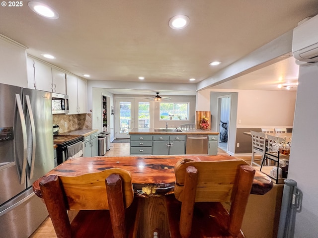 858 E Main St, John Day, OR 97845 - kitchen featuring appliances with stainless steel finishes, recessed lighting, a sink, backsplash, and a wall mounted air conditioner